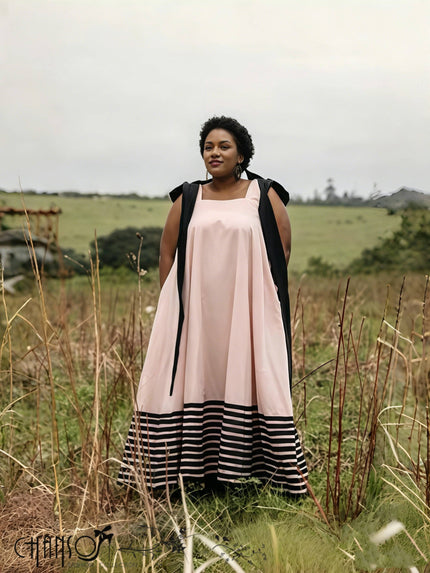Pink square-neck sleeveless maxi dress with black shoulder straps and striped hem panel