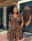 Printed wrap dress with ruffle sleeves and waist belt, dark base with colorful leaf pattern