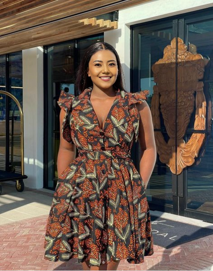 Printed wrap dress with ruffle sleeves and waist belt, dark base with colorful leaf pattern