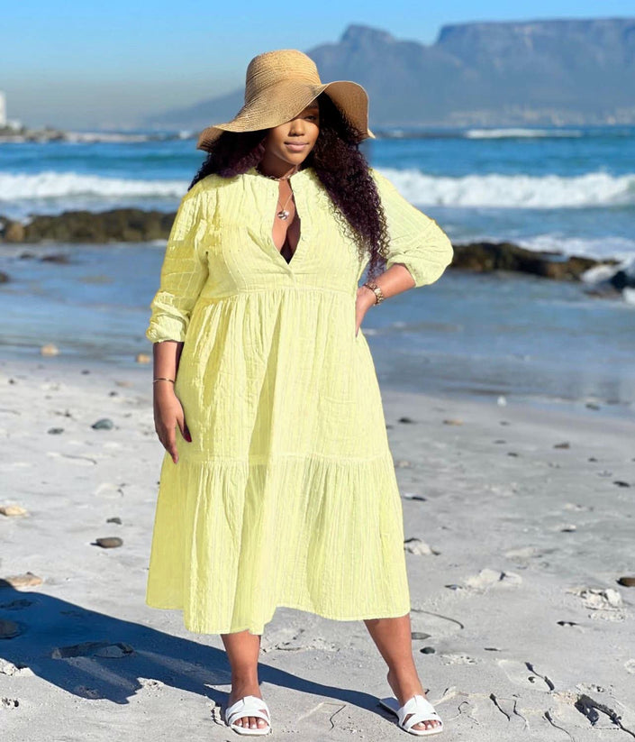 Light yellow tiered maxi dress with V-neck and three-quarter sleeves, keyhole front