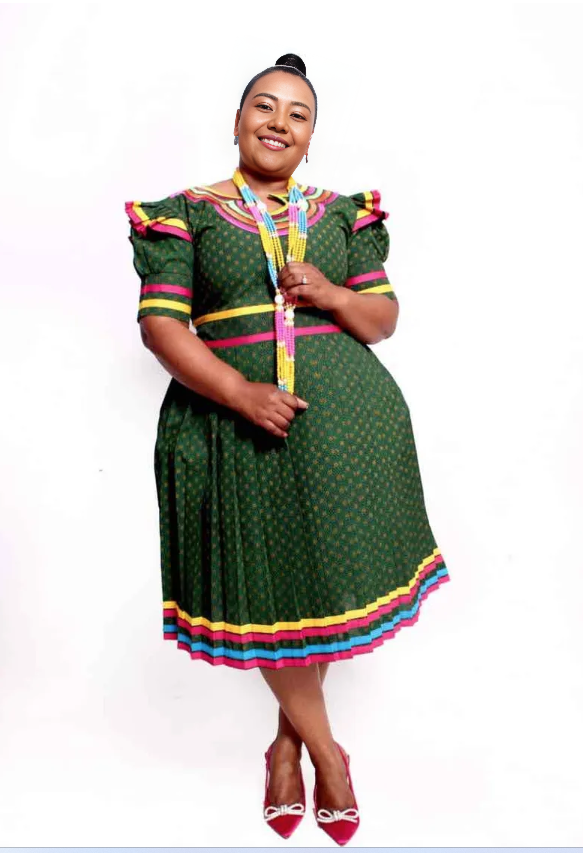 Green puff-sleeve dress with colorful geometric border at sleeves and waist, pleated skirt
