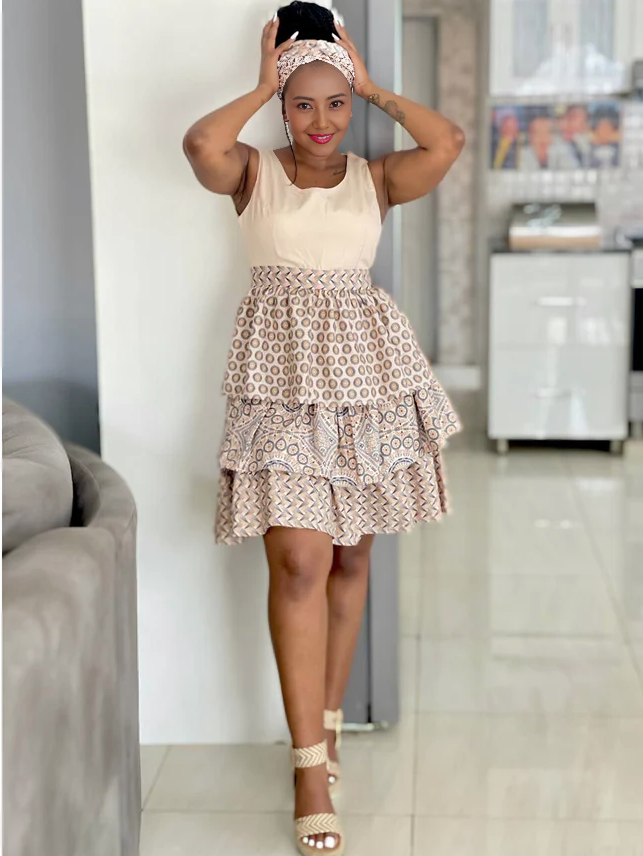 Cream sleeveless mini dress with circular motif layered ruffle skirt