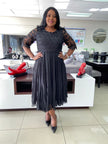 Black lace midi dress with textured bodice, sheer sleeves, gathered waist pleated skirt