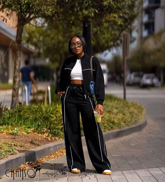Black tracksuit with zip-up jacket and wide-leg pants, white contrast stripe along seams