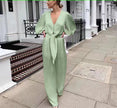 Light green V-neck puff-sleeve jumpsuit with adjustable waist tie and wide-leg pants