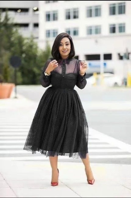 Black midi dress with sheer polka-dot bodice, long sleeves, and flared skirt
