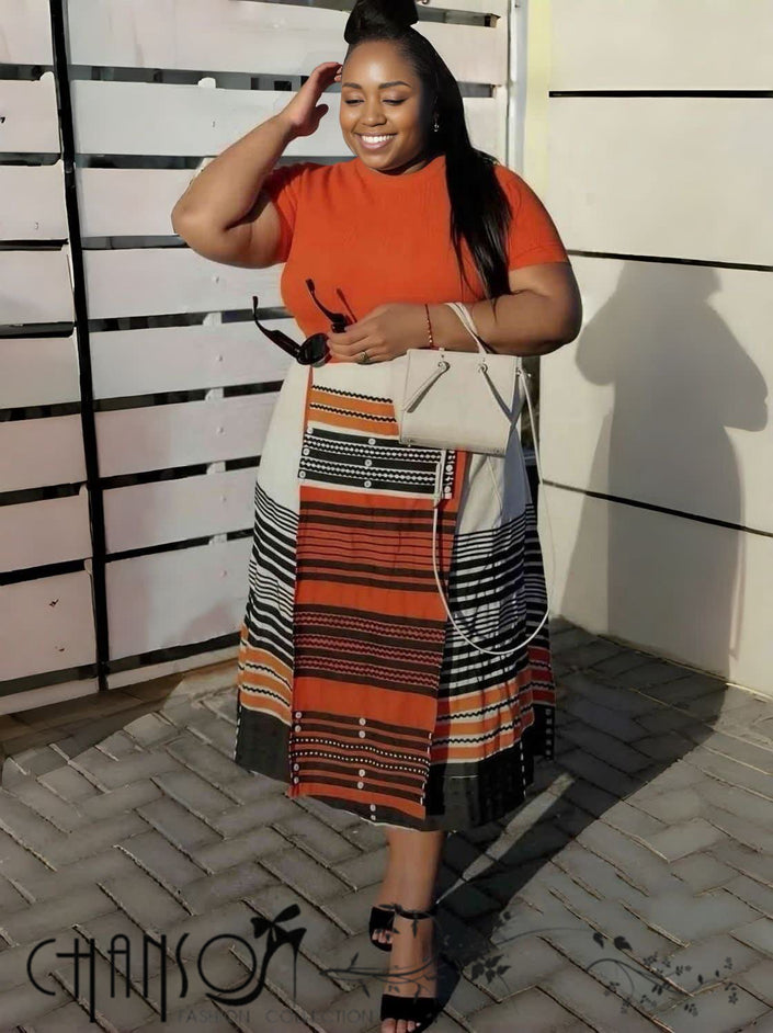 Geometric stripe print dress with orange short-sleeve top and black striped skirt