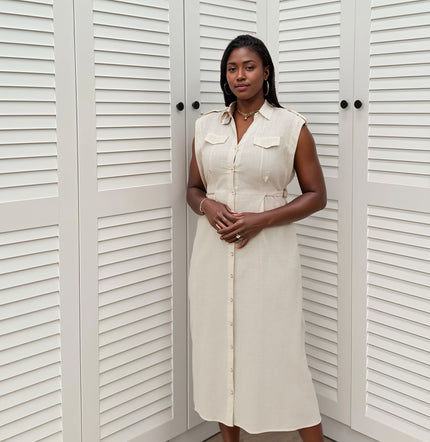 Cream sleeveless midi shirt dress with flap pockets and button front, side seam detailing