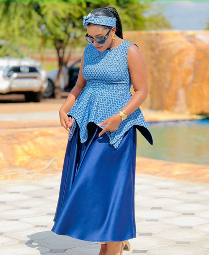 Sleeveless peplum maxi dress with geometric waist detail, blue patterned bodice and dark blue skirt