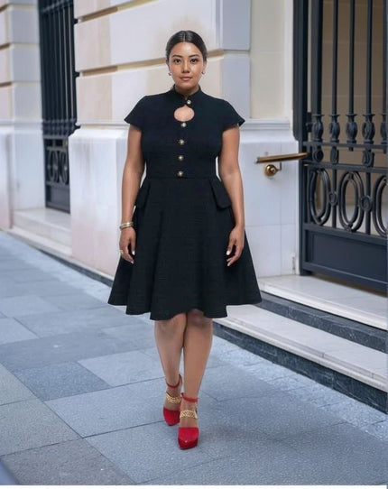 Black vintage dress with cutout neckline, button front, and flared skirt hem