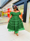 Green midi dress with off-shoulder ruffle neckline and circular motif skirt