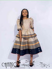 Beige midi dress with puff sleeves, striped tiered skirt in navy and orange accents