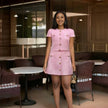 Pink button-front short-sleeve jacket and matching mini skirt suit, gold buttons