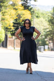 Black A-line midi dress, sleeveless with fitted bodice and flared mid-calf skirt