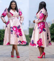 Midi-Kleid mit Puffärmeln, Taillengürtel und großen pinken Blüten auf hellem Stoff