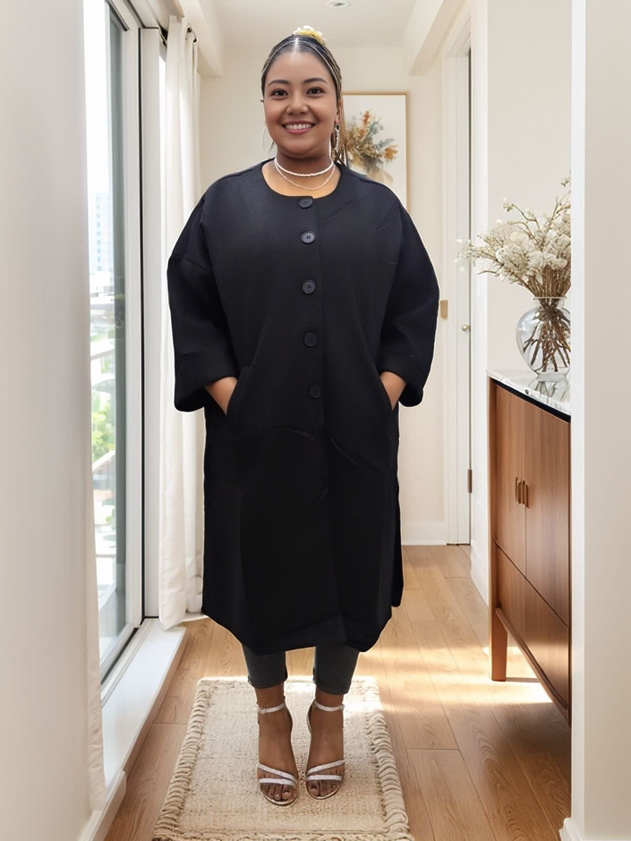Black oversized long coat with button front, round neckline, and curved hem