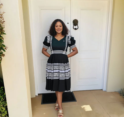 Black midi dress with puff sleeves, embroidered trim, V-neck and striped skirt tiers