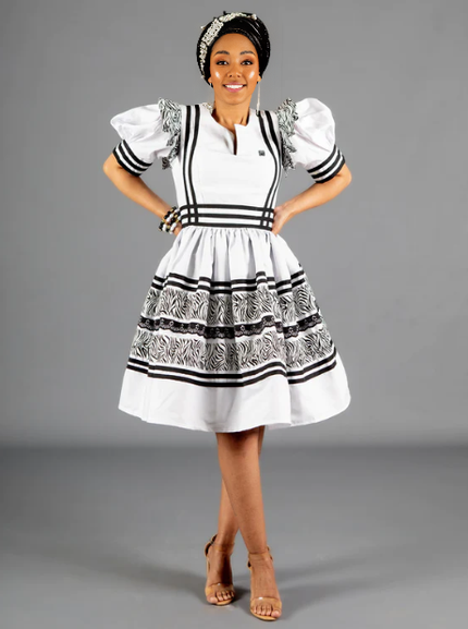 White puff sleeve traditional dress with black striped trim and tiered ruffle skirt