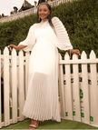 White pleated maxi dress with cinched waist and long, draped sleeves