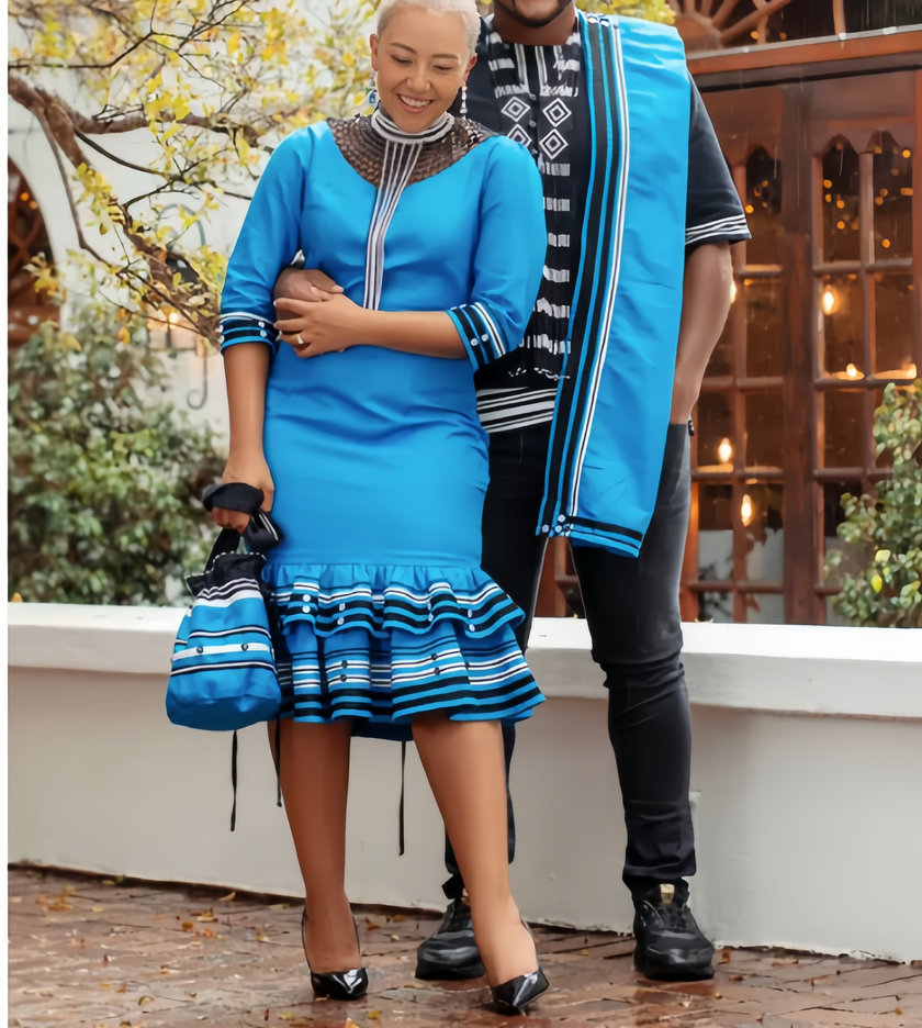 Blaues Kleid mit 3/4 Ärmeln, gestreifter Zierborte und Rüschenrock