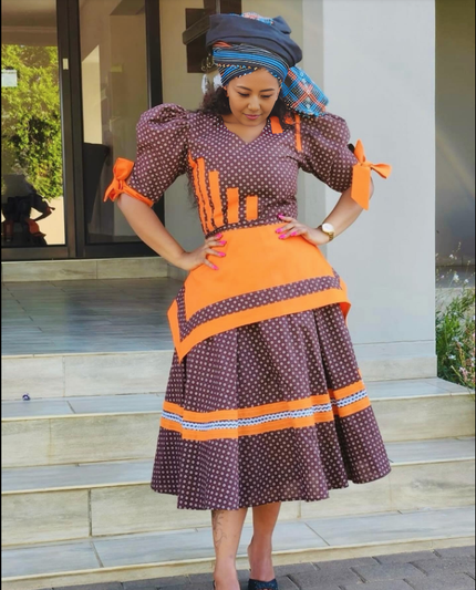 Purple polka-dot midi dress with puff sleeves, orange bows, and striped trim