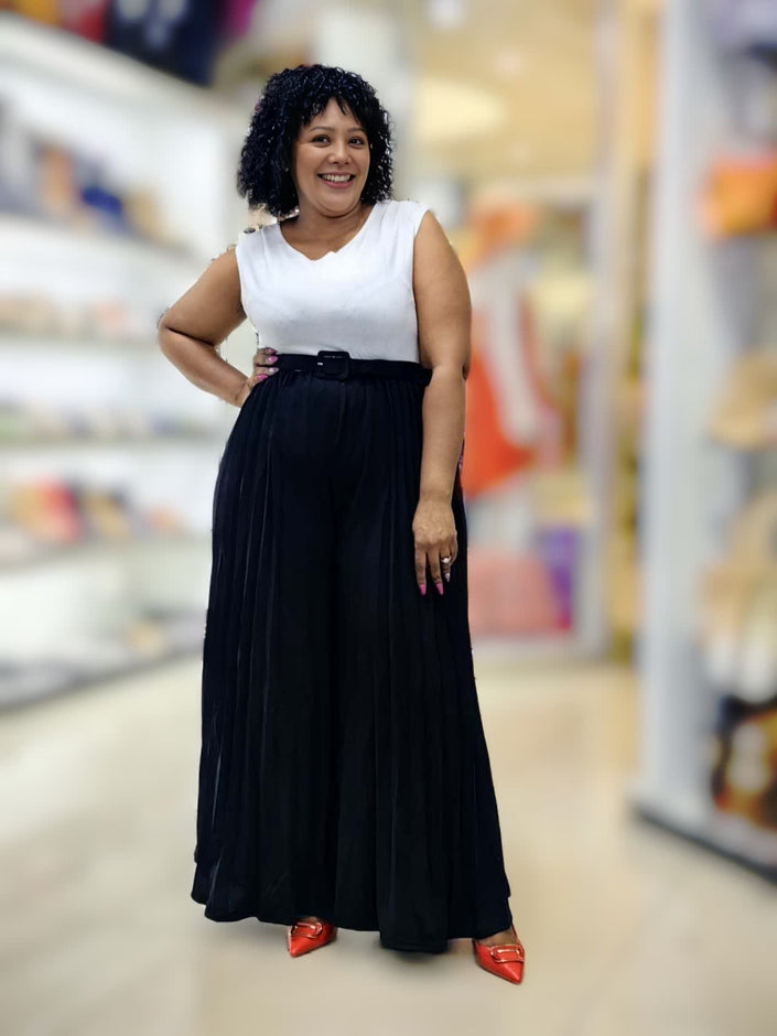 Sleeveless jumpsuit with white top, black pleated wide legs, belted waist