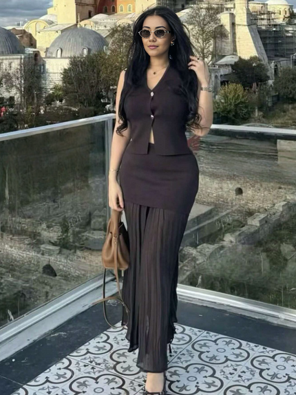 Black pleated midi skirt with matching sleeveless vest, gold button front and V neckline