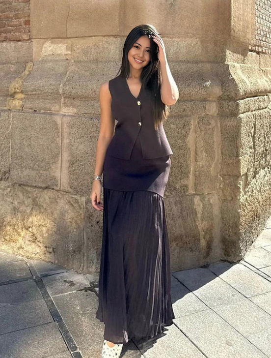 Black pleated midi skirt with matching sleeveless vest, gold button front and V neckline