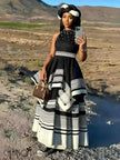 Black beaded maxi dress with high neck, sleeveless; layered black-and-white striped skirt
