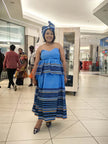 Strapless tiered dress in light blue with striped skirt bands and matching headwrap