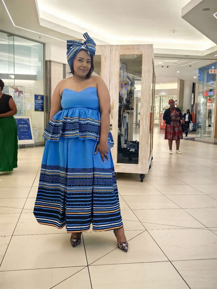 Strapless light-blue maxi dress with striped tiers and navy headwrap