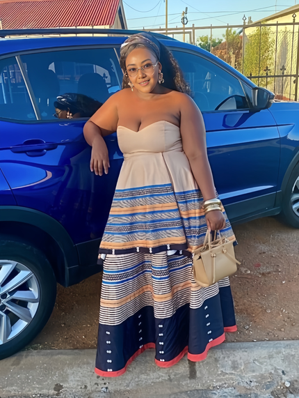 Strapless maxi dress with beige bodice and blue, tan, orange striped skirt