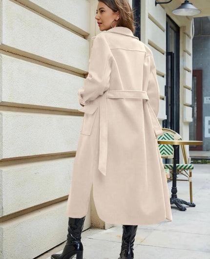 Beige belted knee-length trench coat with tie belt and flap pockets