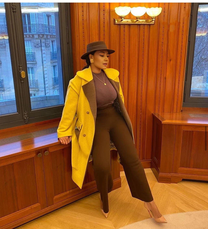 Yellow belted trench coat with notched lapels and double-button front
