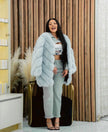 Light-cyan plush fur coat with puffy sleeves, open front, mid-length.