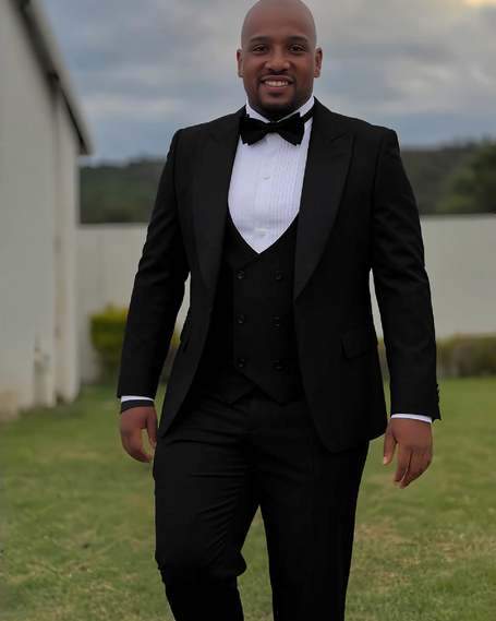 Men's black three-piece tuxedo suit with shawl lapels, white shirt, and bow tie