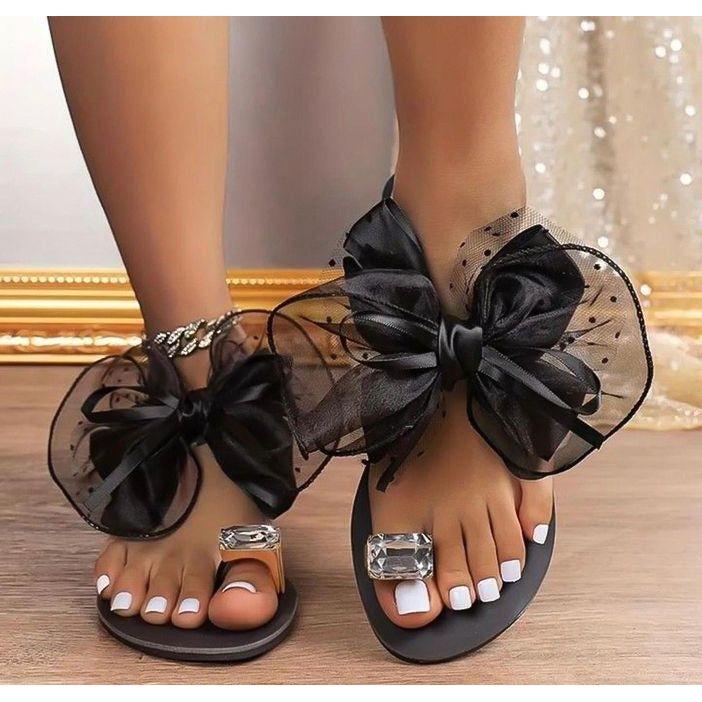 Black sandals with oversized bow and rhinestone buckle, braided chain ankle strap