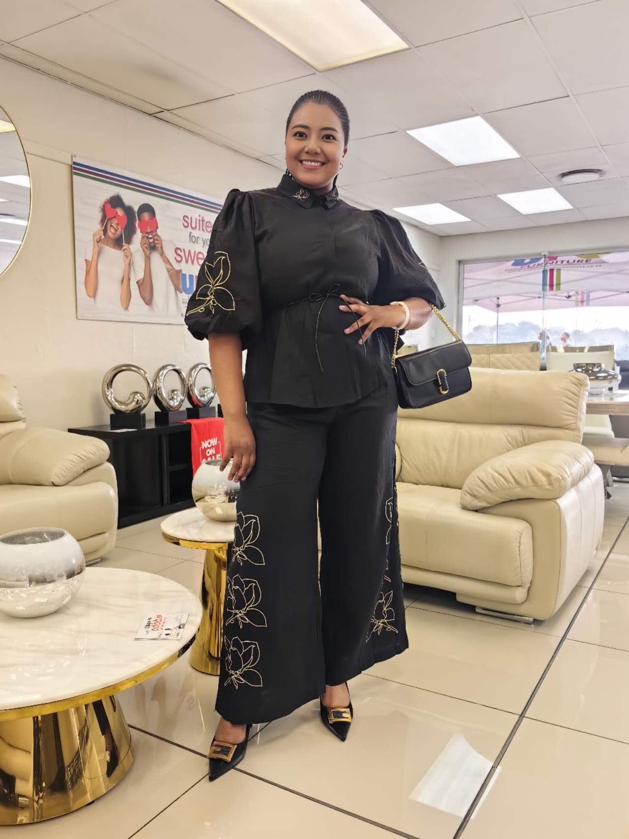 Black twin set with puff sleeves, tied waist blouse and floral-embroidered wide-leg pants