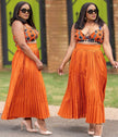 Orange geometric print sleeveless top with pleated midi skirt