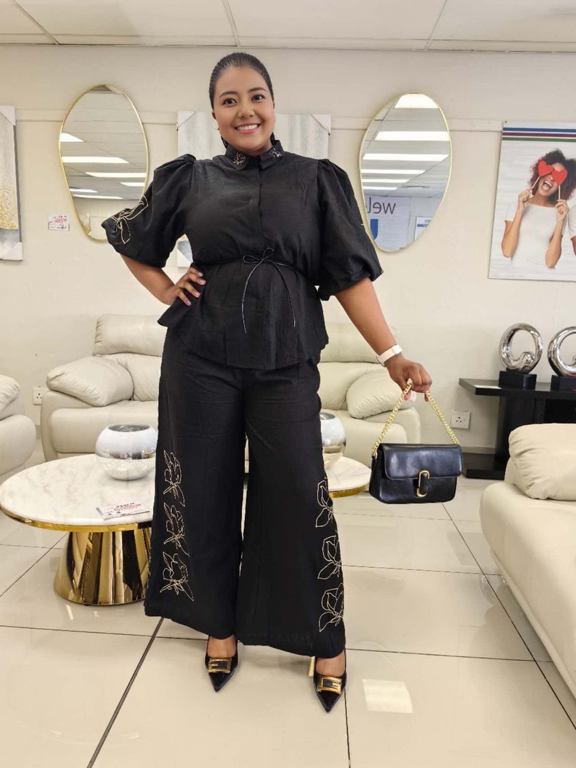 Black puff-sleeve twin set with tied waist blouse and floral-embroidered wide-leg pants