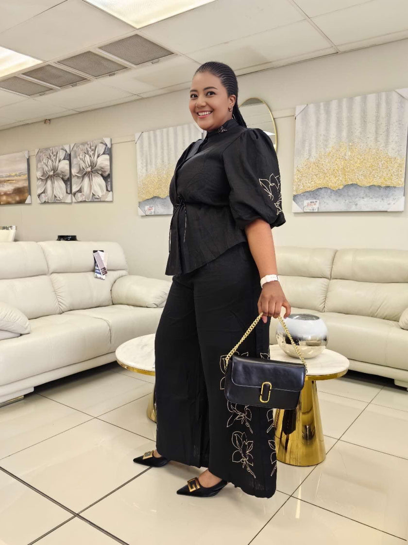 Black puff-sleeve peplum-style top and wide-leg pants twin set with floral trim