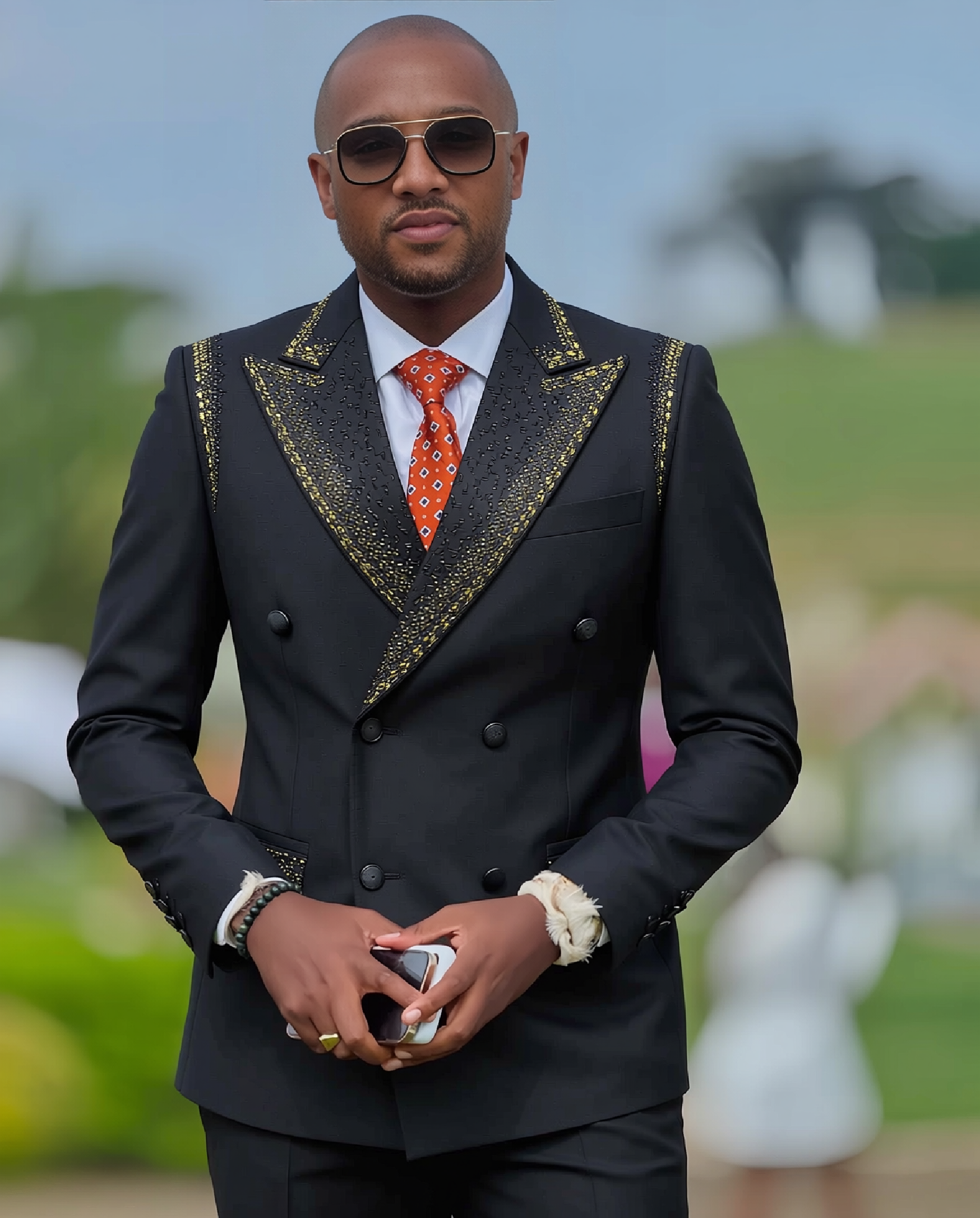 Black tuxedo jacket with gold embroidered peak lapels and double-breasted buttons